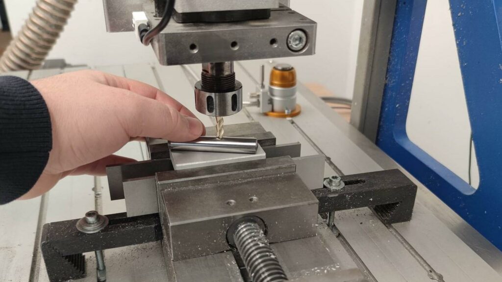 Picture displays how to manually set tool offset with help of dowel pin and retracting the spindle away from the pin until the pin slips under the tool.
