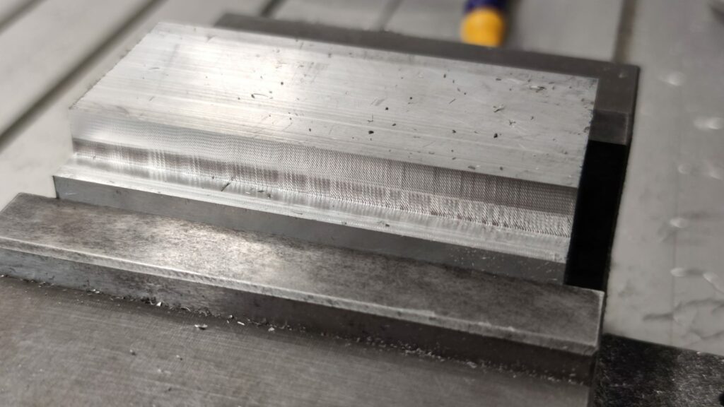 CNC chatter visible on the part. It is recognized as waviness across the freshly milled surface.